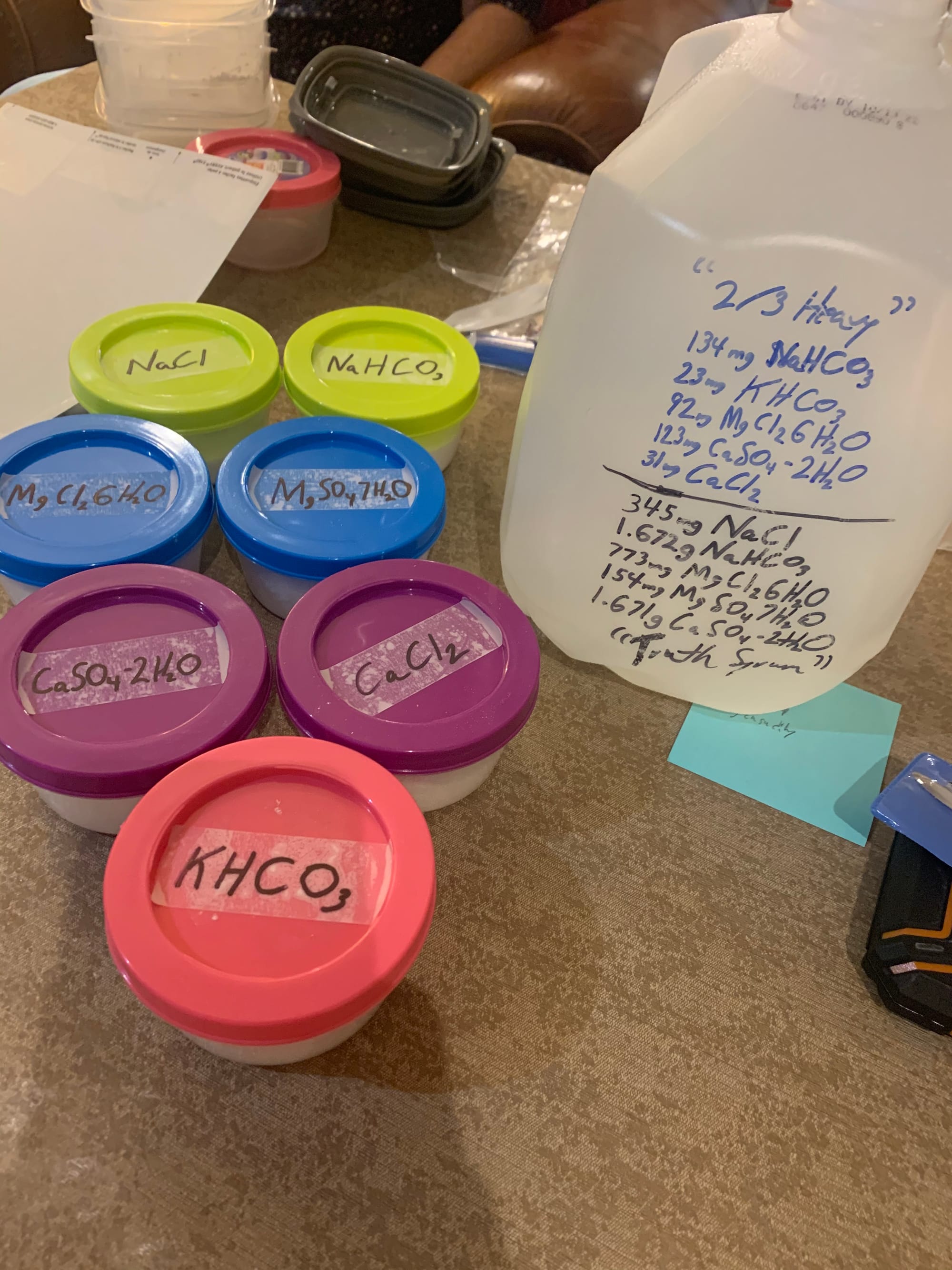 Containers filled with various white powders sporting chemical formula labels.