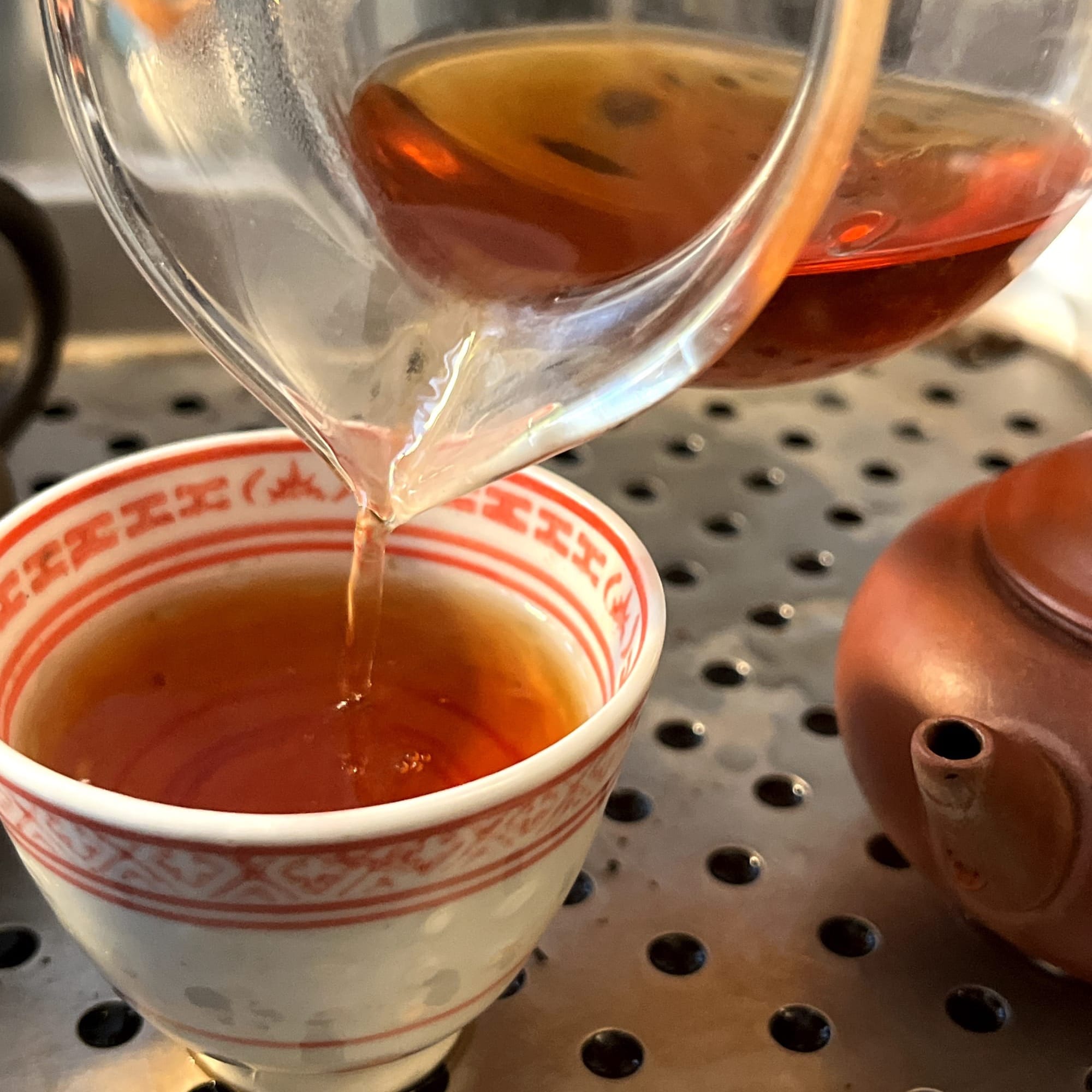 Pouring tea into the tea cup.